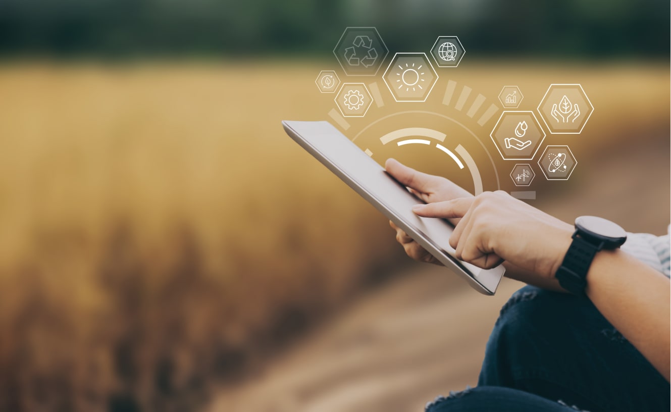 Close-up of hands operating a tablet with augmented reality icons for smart farming, analyzing agricultural data in a golden wheat field